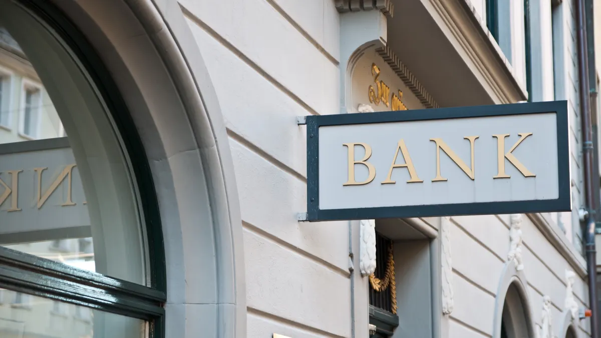 A sign reading "bank" hangs on a building.